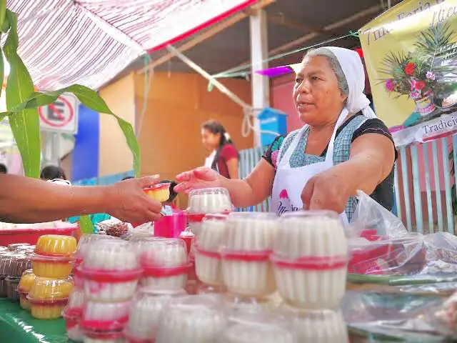 Frau in Oaxaca mit Essen an einem Stand.